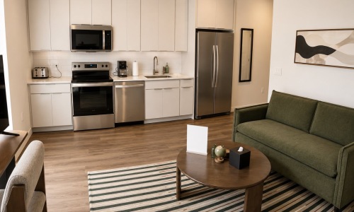 a kitchen with white cabinets and a couch